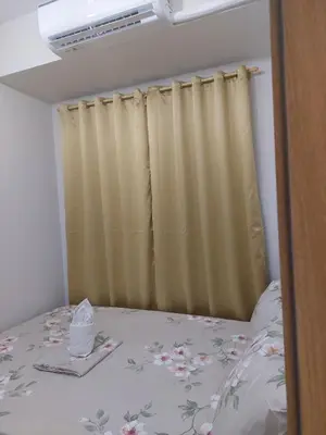 a bedroom with a bed and a curtain at MOA staycation by Elsie D in Manila