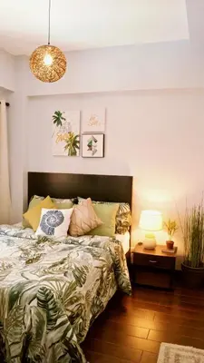 a bedroom with a bed and a table with a lamp at Manila Airport Staycation near NAIA Terminal 3 in Manila