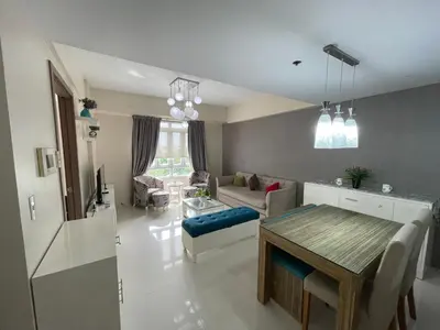 a living room with a table and a couch at 150 Newport Blvd - Near T3 Airport in Manila
