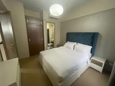 a bedroom with a white bed and a blue headboard at 150 Newport Blvd - Near T3 Airport in Manila