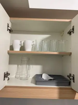 a kitchen shelf with glasses and a blender on it at Condo for Families and Friends in Manila