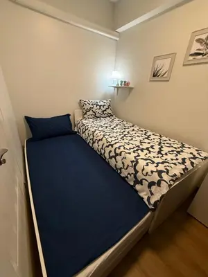 a small bedroom with a bed with a blue comforter at Condo for Families and Friends in Manila