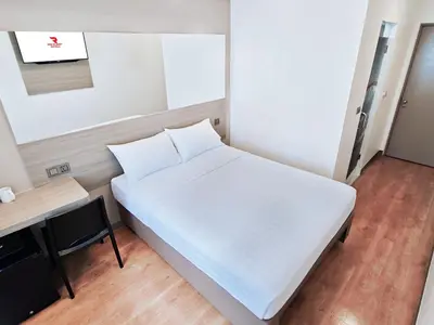 a large white bed in a room with a desk at Red Planet Manila Aseana City in Manila