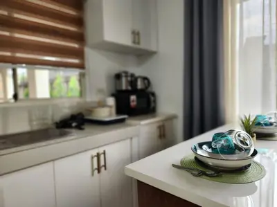 a kitchen with white cabinets and a bowl on a counter at Amari Homestay @ Sorrento Oasis Condominium in Manila