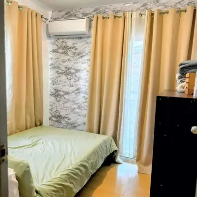 a small bedroom with a bed and a window at Amari Homestay @ Sorrento Oasis Condominium in Manila