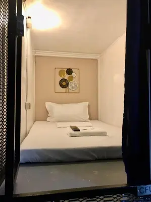 a bedroom with a bed with a book on it at Budget Transient Capsule Room Mirasol Near BGC in Manila