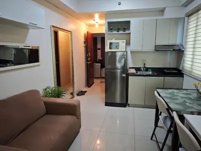 a kitchen and living room with a couch and a table at My Quiet Place at The Beacon - Makati City in Manila