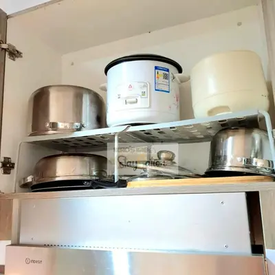 a kitchen shelf with pots and pans on it at Condo in Pasay S Residences in Manila