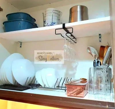 a shelf with dishes and utensils on it at Condo in Pasay S Residences in Manila