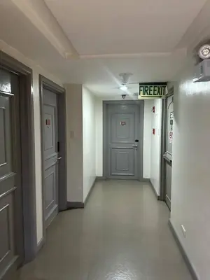 an empty hallway with a fire exit sign on the wall at Exquisite Stays Private 2BR Rental in Manila