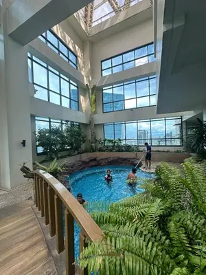 a group of people in a swimming pool in a building at Exquisite Stays Private 2BR Rental in Manila