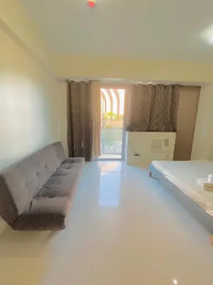 a room with a couch and a bed and a window at Kiel 5-Star Condo Hotel Across NAIA Manila Airport Terminal 3 in Manila