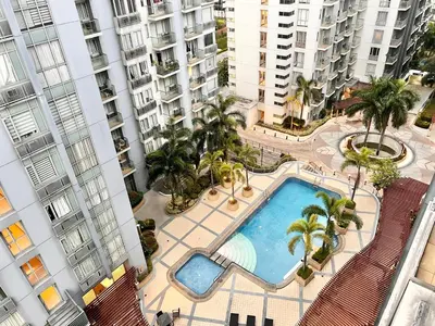 an overhead view of a swimming pool with palm trees and buildings at Kiel 5-Star Condo Hotel Across NAIA Manila Airport Terminal 3 in Manila
