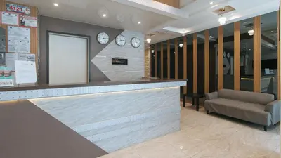 a lobby with a bar with a chair and clocks at RedDoorz Plus @ Bez Tower and Residences San Juan in Manila