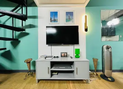 a living room with a tv on a blue wall at Casa Jessica 329 Dubai style One bedroom Corner unit in Bacoor
