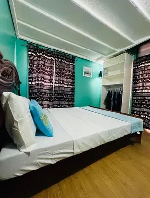 a bedroom with a large bed with a blue wall at Casa Jessica 329 Dubai style One bedroom Corner unit in Bacoor