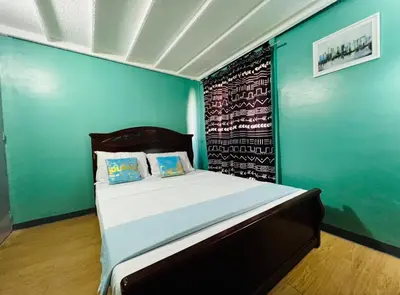a bedroom with a bed with a blue wall at Casa Jessica 329 Dubai style One bedroom Corner unit in Bacoor