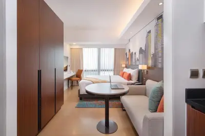 a hotel room with a bed and a couch and a table at Citadines Benavidez Makati in Manila