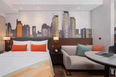 a bedroom with a bed and a couch and a city at Citadines Benavidez Makati in Manila
