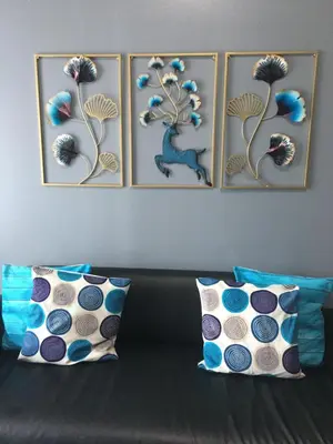 four pictures on a wall above a couch with pillows at Simple & Cozy 1 Bedroom US Embassy, Roxas Blvd, Ermita, Manila in Manila