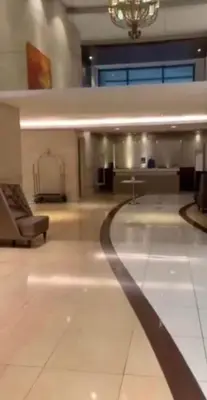 a large empty room with a couch and a chandelier at Simple & Cozy 1 Bedroom US Embassy, Roxas Blvd, Ermita, Manila in Manila