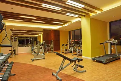 a gym with several exercise equipment in a room at Simple & Cozy 1 Bedroom US Embassy, Roxas Blvd, Ermita, Manila in Manila