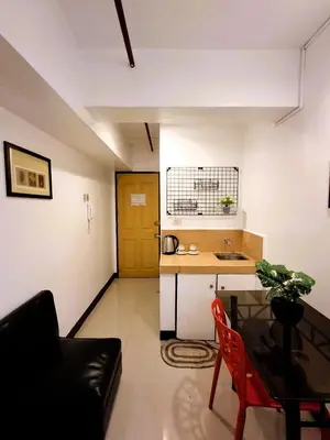 a living room with a table and a kitchen at Makati Poblacion Hotel in Manila