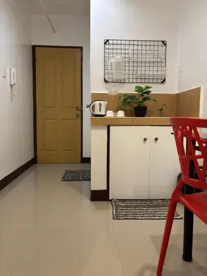 a kitchen with a red chair and a door at Makati Poblacion Hotel in Manila