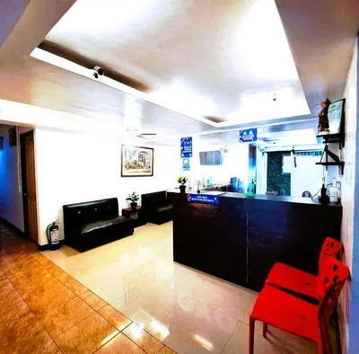 a living room with a red chair and a bar at Makati Poblacion Hotel in Manila