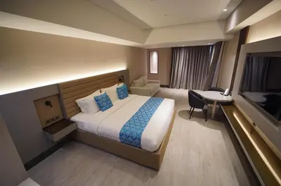 a hotel room with a large bed and a desk at Bayprime Hotel in Manila