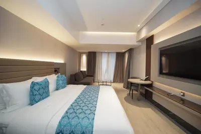 a hotel room with a large bed and a flat screen tv at Bayprime Hotel in Manila