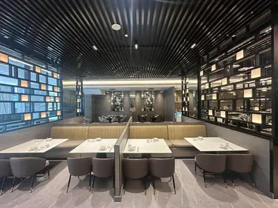 a dining room with tables and chairs and a bar at Bayprime Hotel in Manila