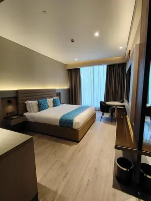a hotel room with a bed and a television at Bayprime Hotel in Manila