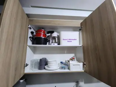 a cupboard filled with kitchen utensils and appliances at SMDC Shore 2 Minimalist Home in Manila
