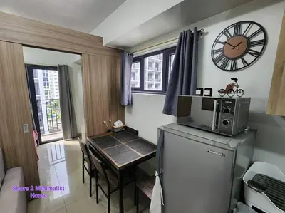 a kitchen with a table and a clock on the wall at SMDC Shore 2 Minimalist Home in Manila