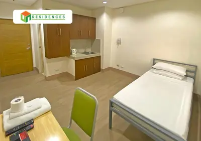a small room with a bed and a table and chairs at UN Residences in Manila