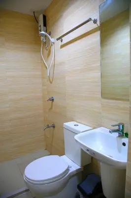 a bathroom with a toilet and a sink at UN Residences in Manila
