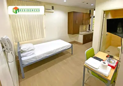 a small hospital room with a bed and a desk at UN Residences in Manila