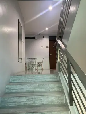 a staircase in a house with a table on it at ABE Lodge Taguig in Manila