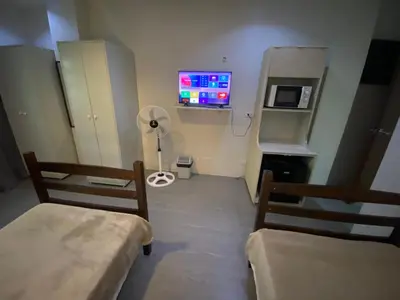 a hospital room with two beds and a tv at ABE Lodge Taguig in Manila