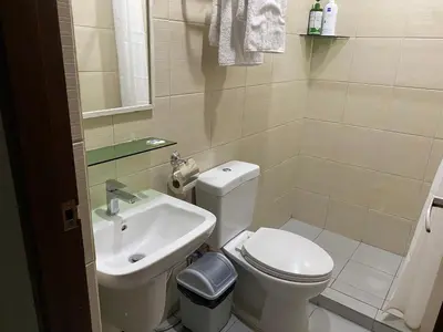 a small bathroom with a toilet and a sink at ABE Lodge Taguig in Manila