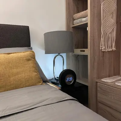 a bedroom with a bed with a lamp next to it at Evan Suite S Residences T1 in Manila