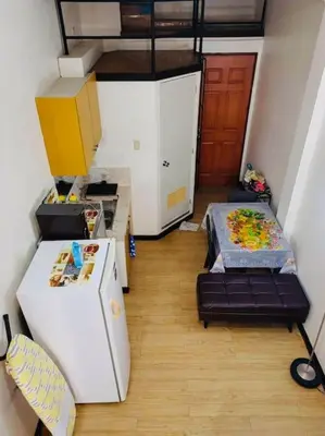 a small room with a refrigerator and a table at Casa Jessica 326 Heavens Place One bedroom plus loft Condo Unit in Bacoor