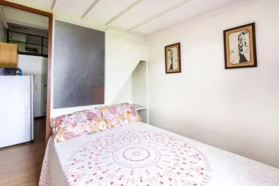 a bedroom with a bed with a pink bedspread and a refrigerator at Casa Jessica 326 Heavens Place One bedroom plus loft Condo Unit in Bacoor