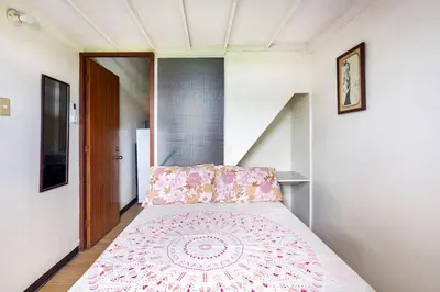 a bed with a pink bedspread in a room at Casa Jessica 326 Heavens Place One bedroom plus loft Condo Unit in Bacoor