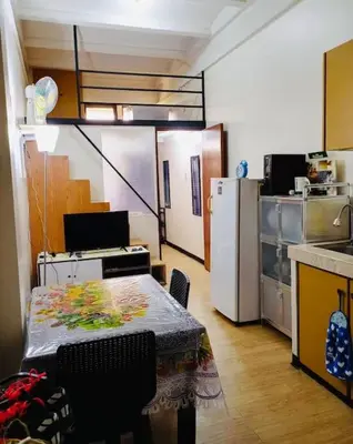 a small kitchen with a table and a refrigerator at Casa Jessica 326 Heavens Place One bedroom plus loft Condo Unit in Bacoor