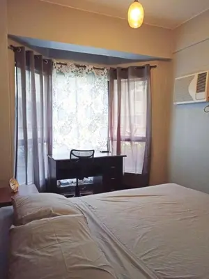 a bedroom with a bed and a desk in front of a window at 1BR Condo at Montecito Newport City Residential Resort across NAIA and Marriott Hotel in Manila