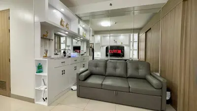 a living room with a couch and a tv at Mall of Asia Shore 2 Condo in Manila
