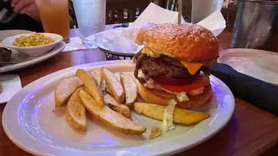 a plate with a hamburger and french fries on a table at Mall of Asia Shore 2 Condo in Manila