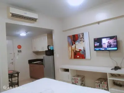 a room with a kitchen with a tv on the wall at Pasay Condotel near NAIA terminal 3 (3 mins walk in) in Manila
